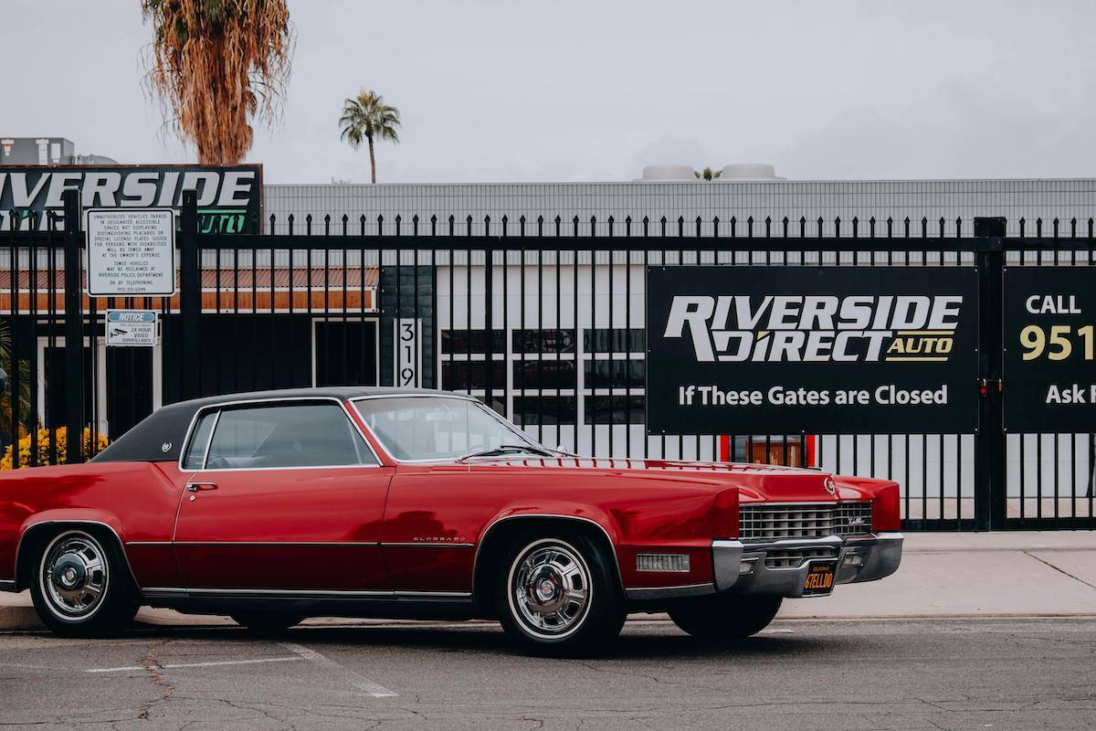 Cadillac Eldorado in front of used car dealership