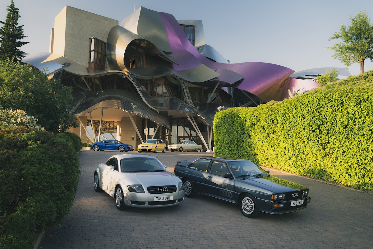Group of Audi cars from the past 60 years parked in front of Hotel Marques de Riscal