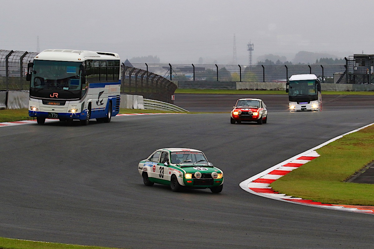 Buses and race cars on track at Fuji Speedway