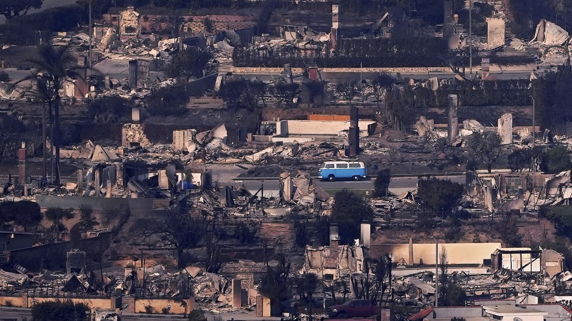 A Volkswagen bus sits among burned out homes, January 9, 2025, in Malibu, California (Image: AP Photo/Mark J. Terrill)