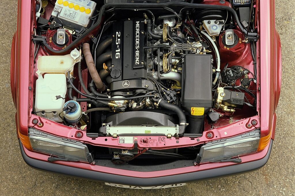 Mercedes-Benz 190 E 2.5-16 (1988 bis 1993) der Baureihe 201, Blick in den Motorraum. Mercedes-Benz 190 E 2.5-16 (1988 to 1993) of the 201 series, engine compartment.
