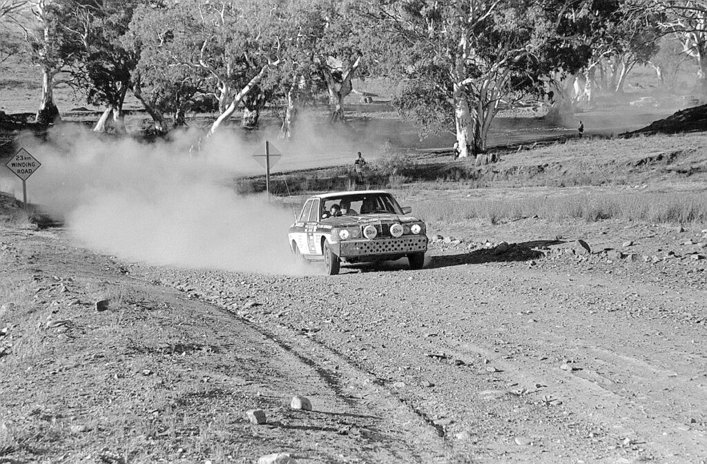 Doppeltriumph nach 30.000 Kilometern: Zwei Mercedes-Benz 280 E der Baureihe 123 gewinnen 1977 die Rallye London–Sidney. Das Foto zeigt das Siegerfahrzeug von Andrew Cowan/Colin Malkin/Mike Broad auf einer australischen Schotterpiste. Es kann heute im Mercedes-Benz Museum erlebt werden. (Fotosignatur der Mercedes-Benz Classic Archive: R10007) Double triumph after 30,000 kilometres: Two Mercedes-Benz 280 E vehicles of the 123 model series win the 1977 London–Sydney Rally. The photo shows the winning vehicle of Andrew Cowan/Colin Malkin/Mike Broad on an Australian dirt road. It can be seen today at the Mercedes-Benz Museum. (Photo index number in the Mercedes-Benz Classic Archive: R10007)