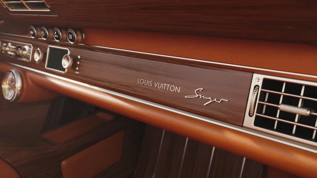Interior detail showing wood dash strip with gold Louis Vuitton and Singer emblems